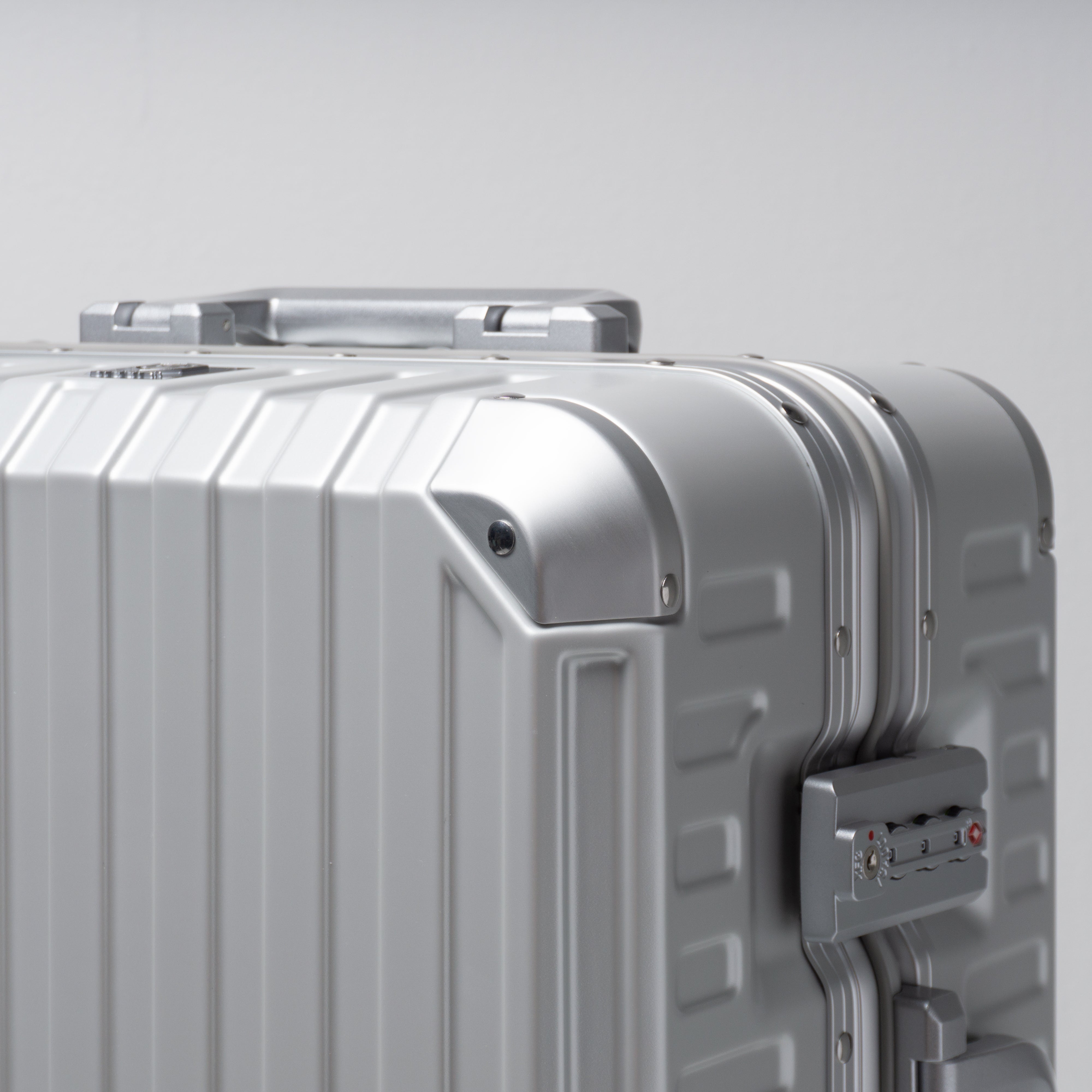 Silver suitcase with a textured surface on a light gray background