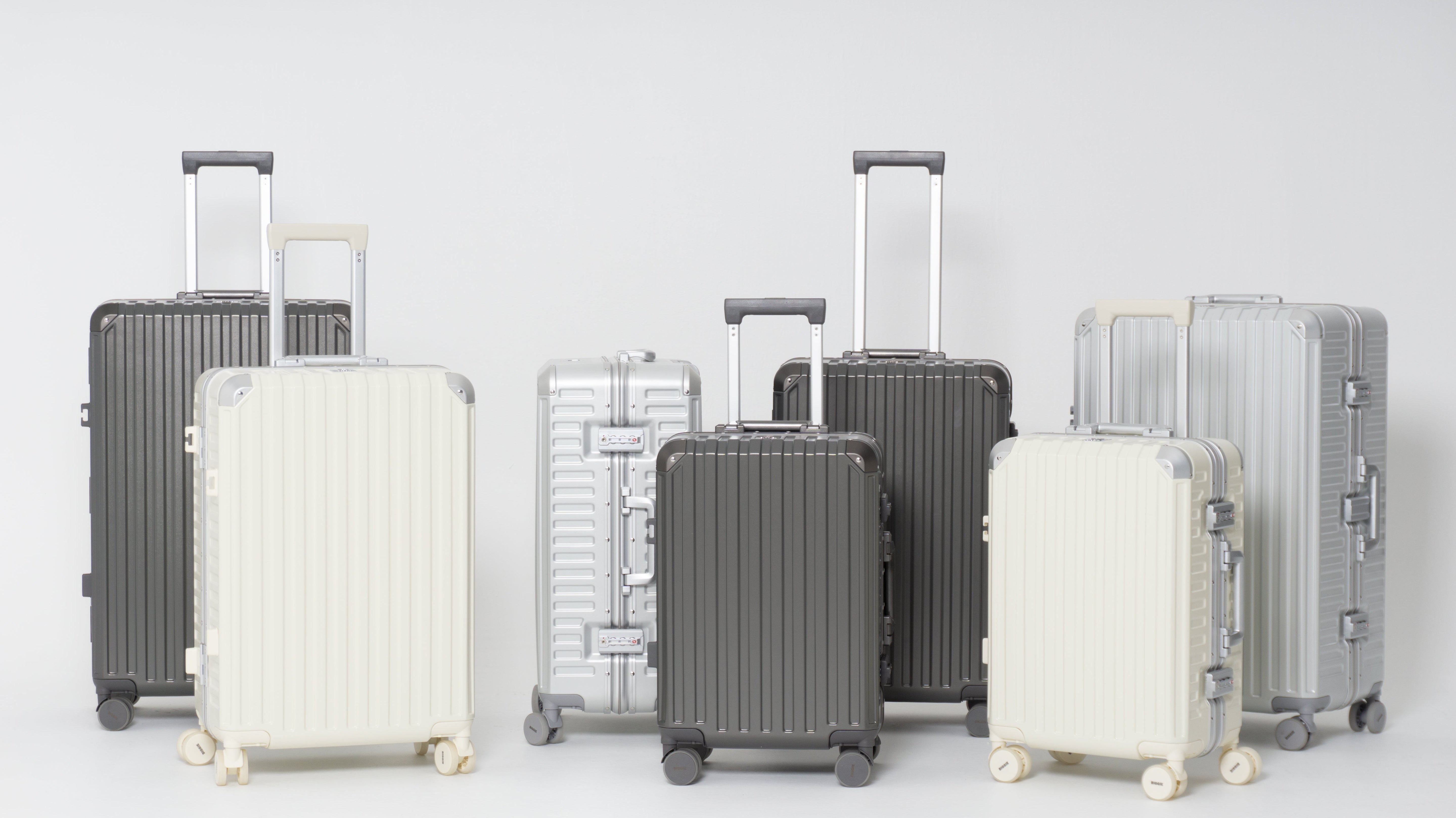 Set of suitcases in various colors on a light gray background
