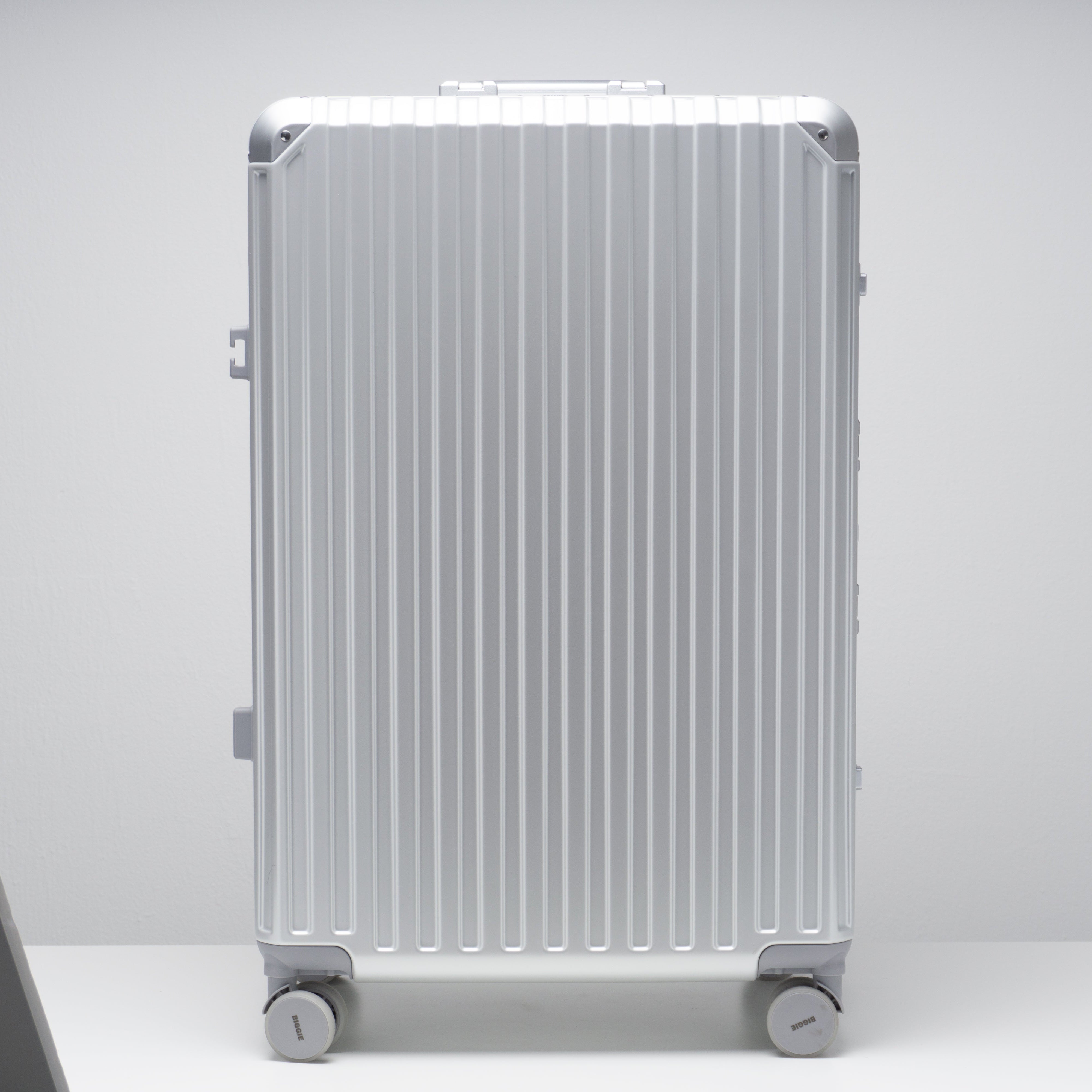 Silver suitcase with wheels on a white background